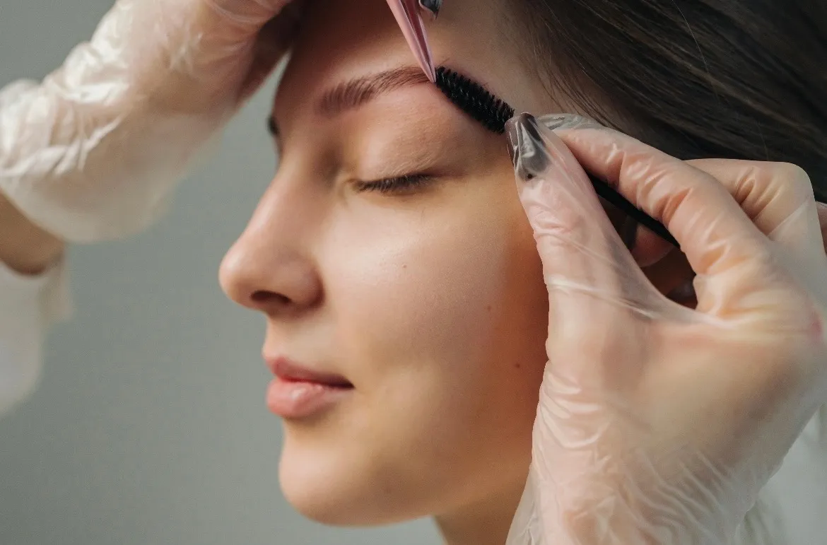 Permanent makeup brow grooming with spoolie brush — natural, refined PMU artistry at Jinny's Beauty Studio